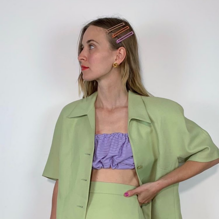 A woman wearing 3 hairclips of assorted colors