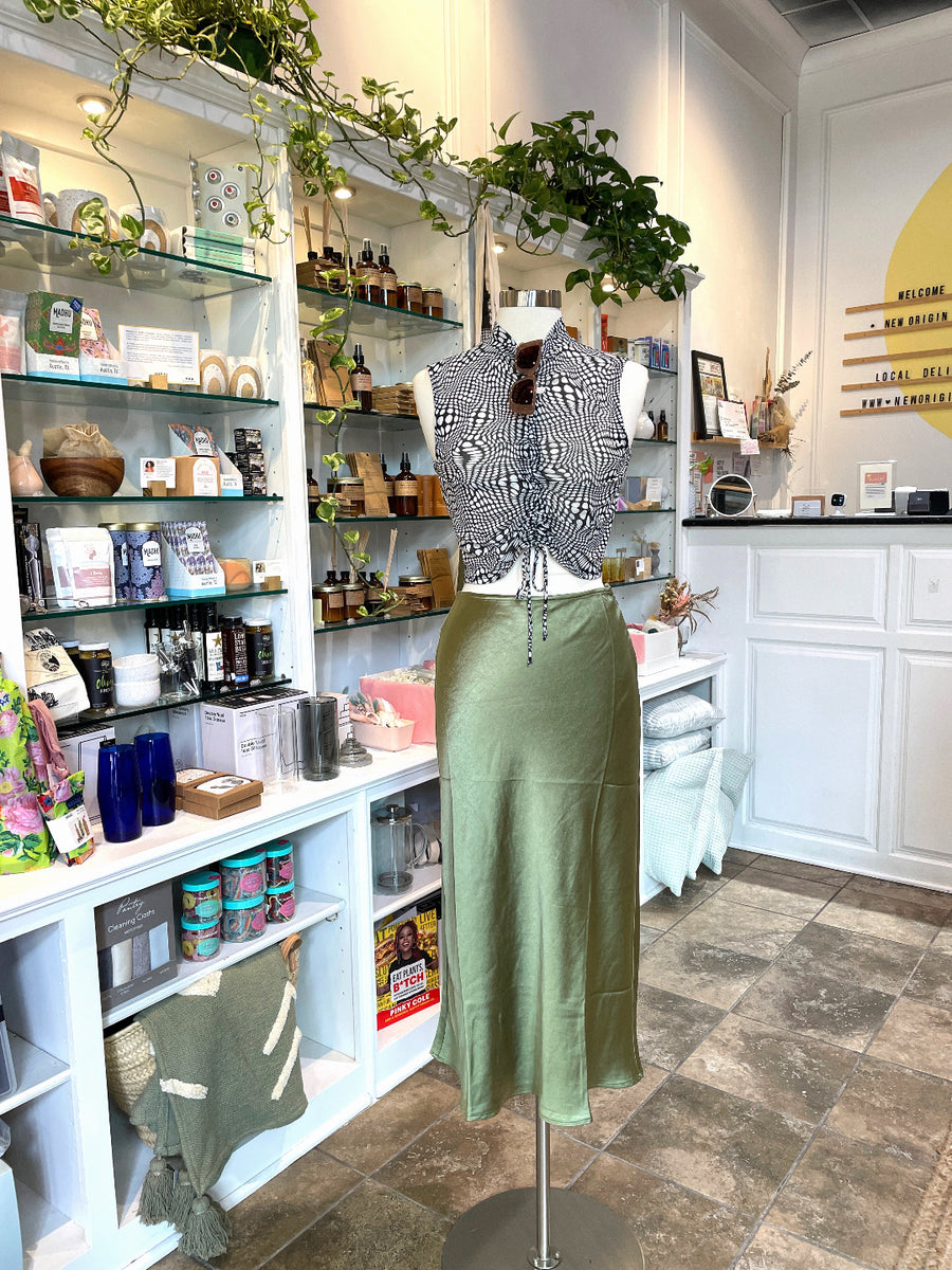mannequin in a boutique wearing a black and white top with a green skirt