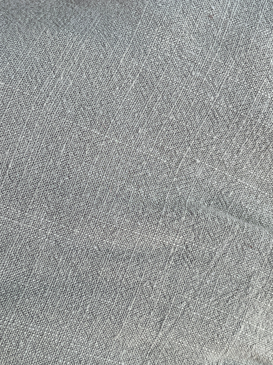 Close-up texture image of a linen jumpsuit in a neutral color.