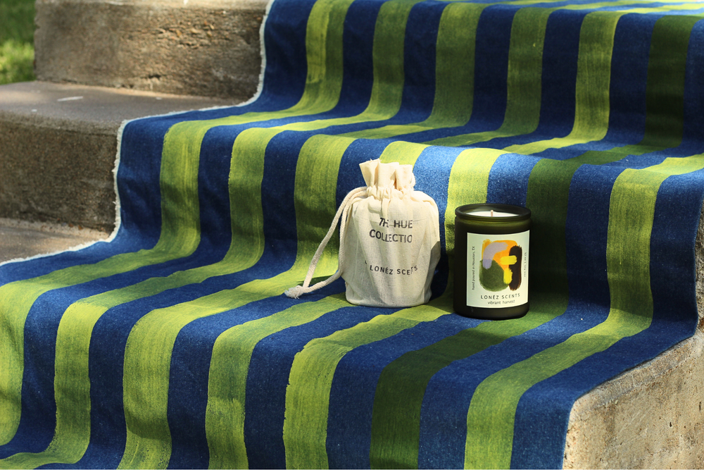 Striped blue and green towel on steps with a bag and jar on top