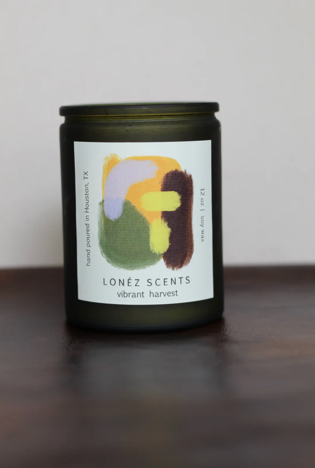 Candle with a colorful label on a wooden surface