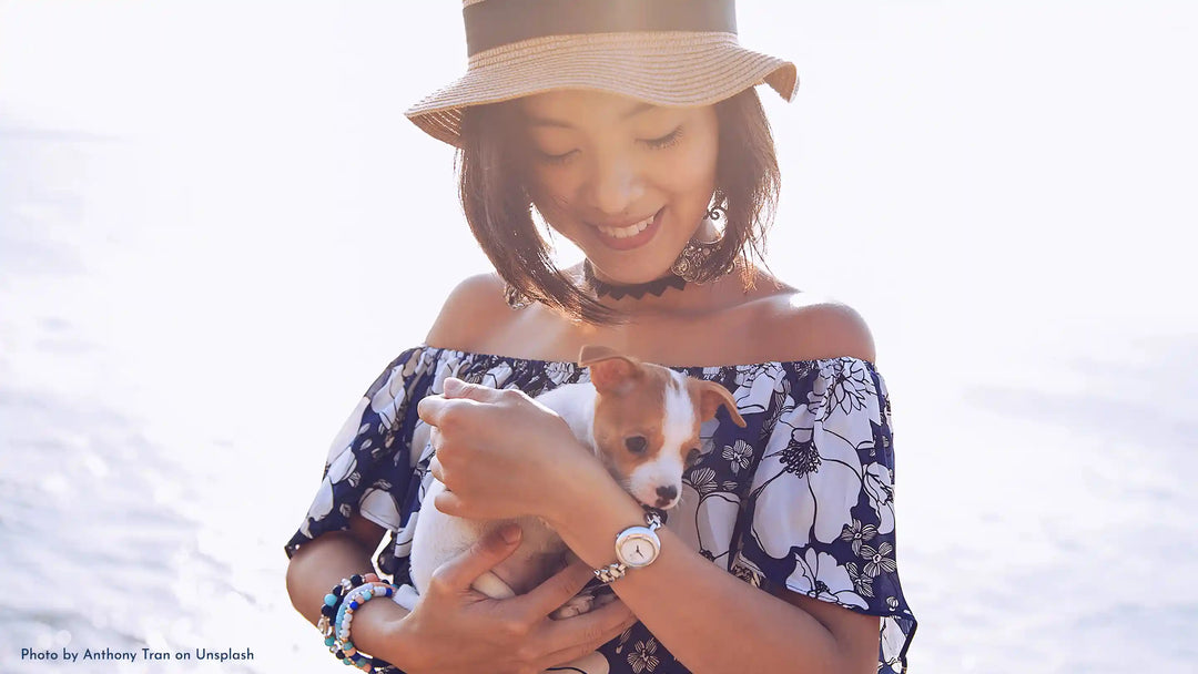 A woman holding a small puppy