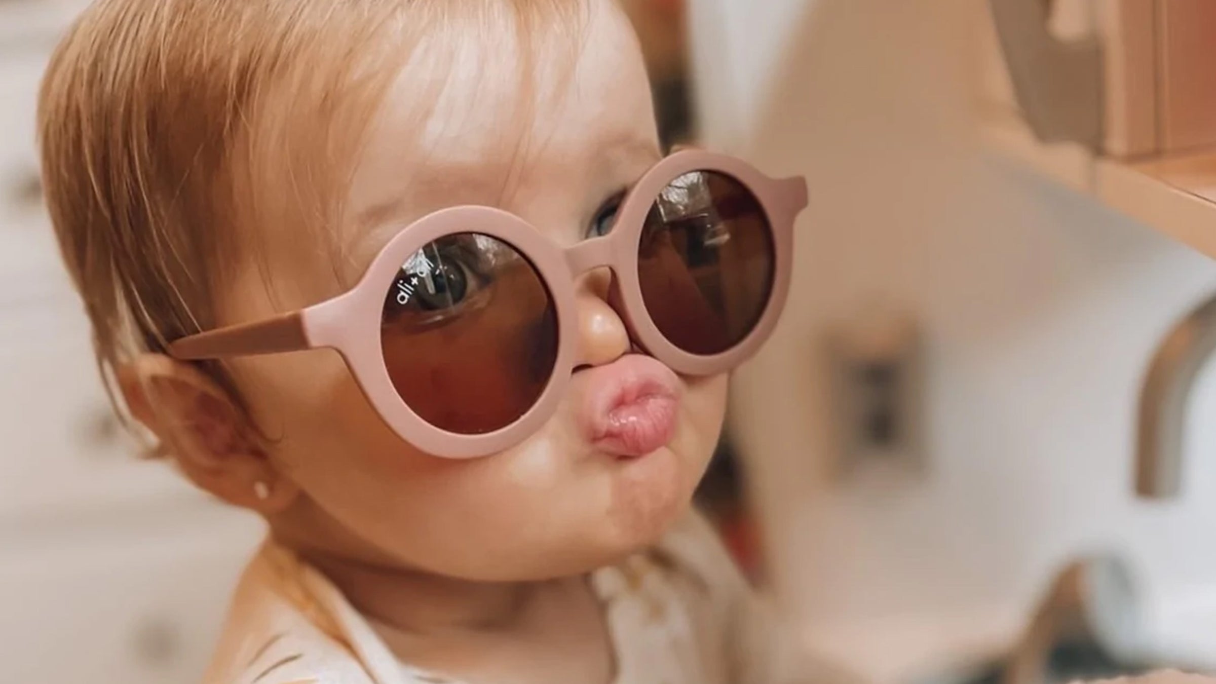 Baby wearing pink sunglasses