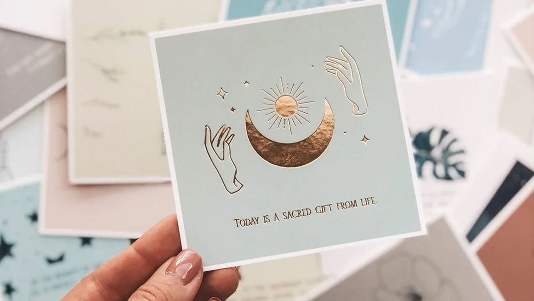 Female hand holding a Lamere affirmation card over other cards