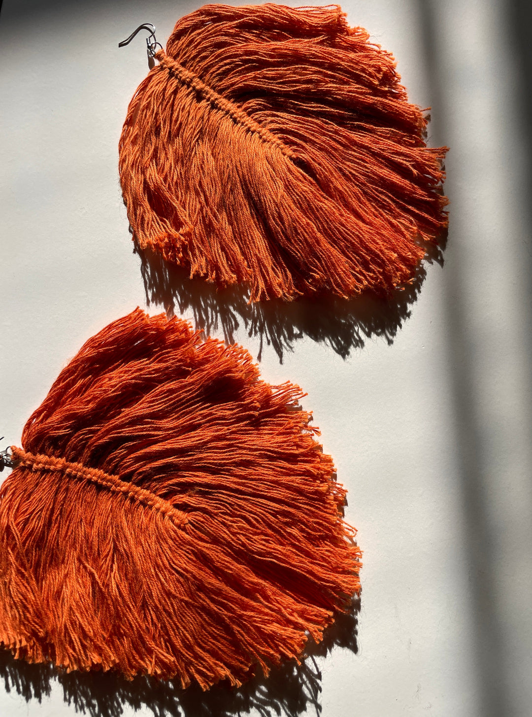 two orange macrame feather earrings