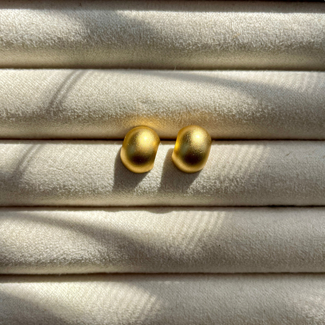 a pair of gold colored stud earrings