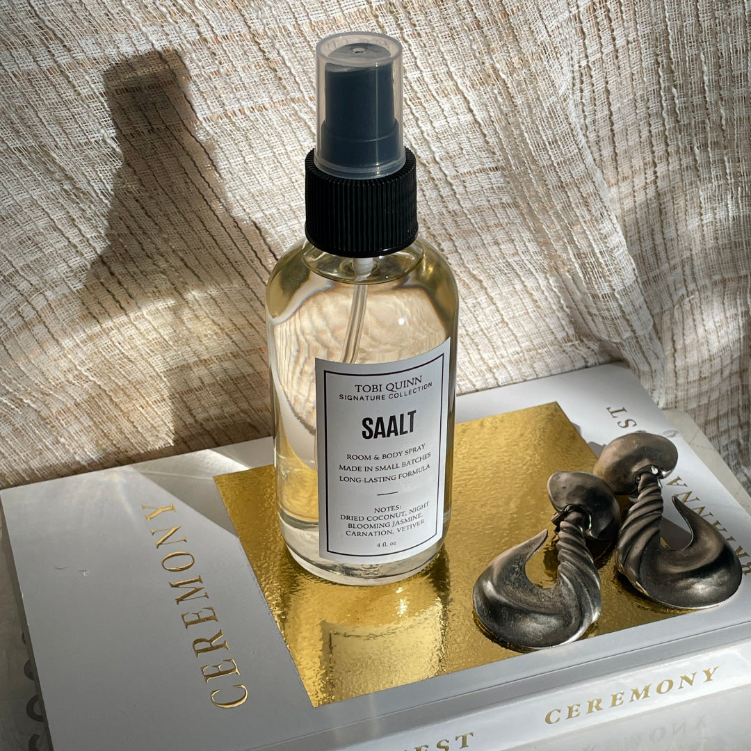 Saltt Body spray and earrings on a book