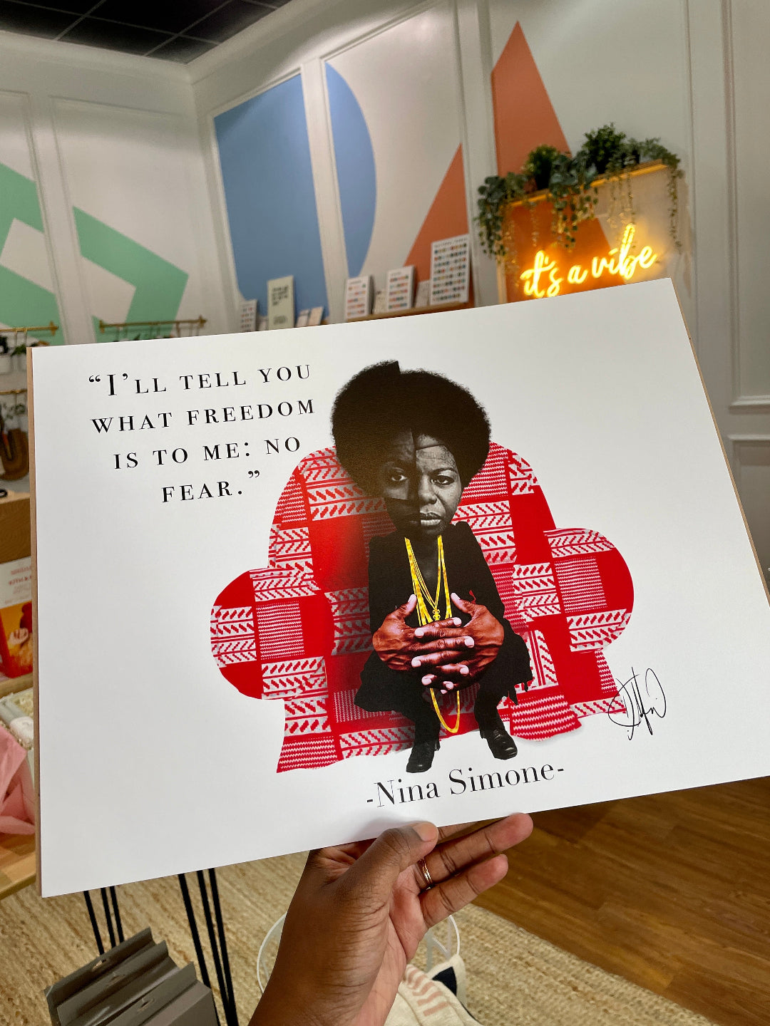 hand holding artwork "I'LL TELL YOU WHAT FREEDOM IS TO ME: NO FEAR" NINA SIMONE