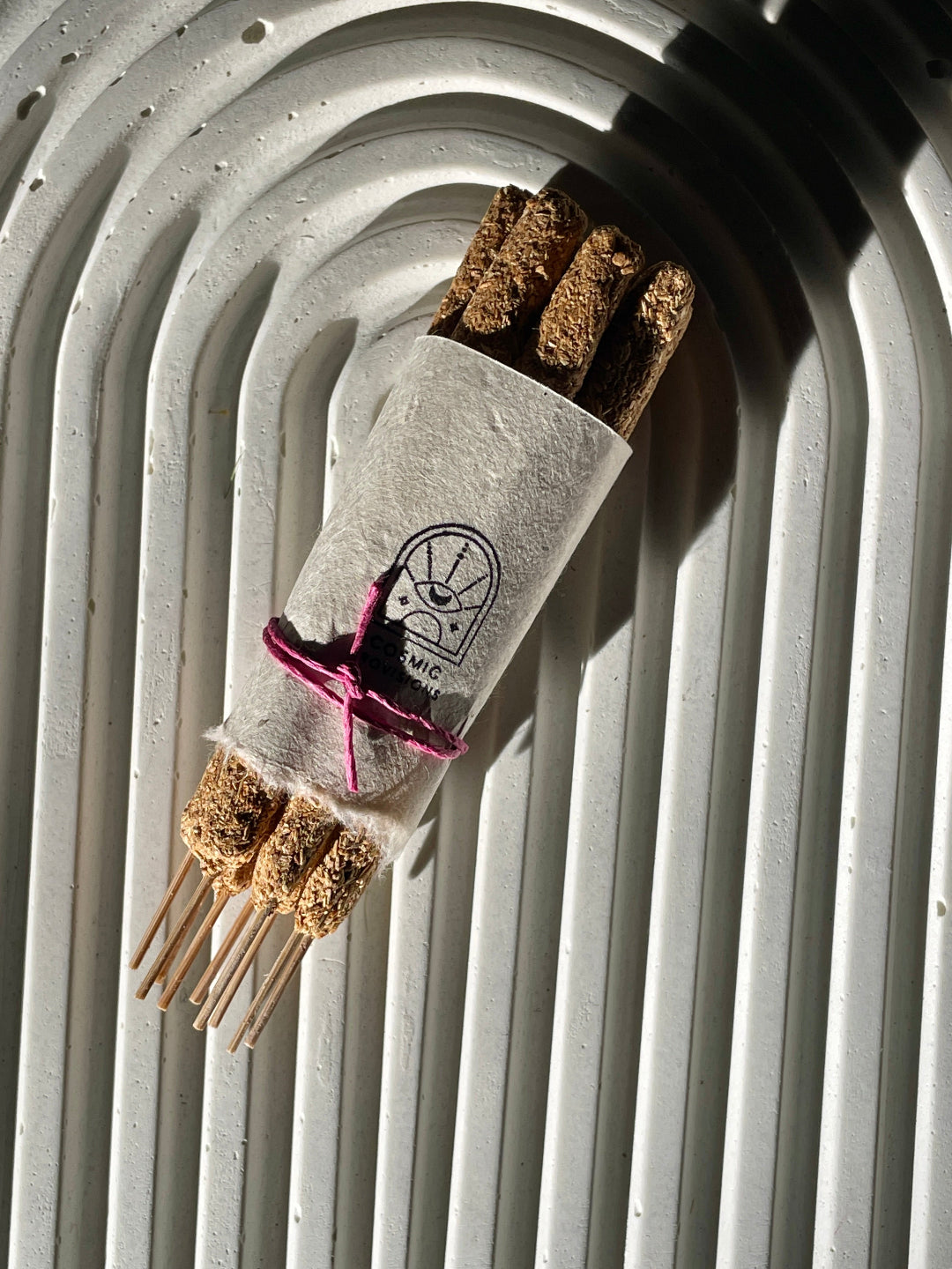 Hand rolled Cosmic Provisions Palo Santo incense on stone background