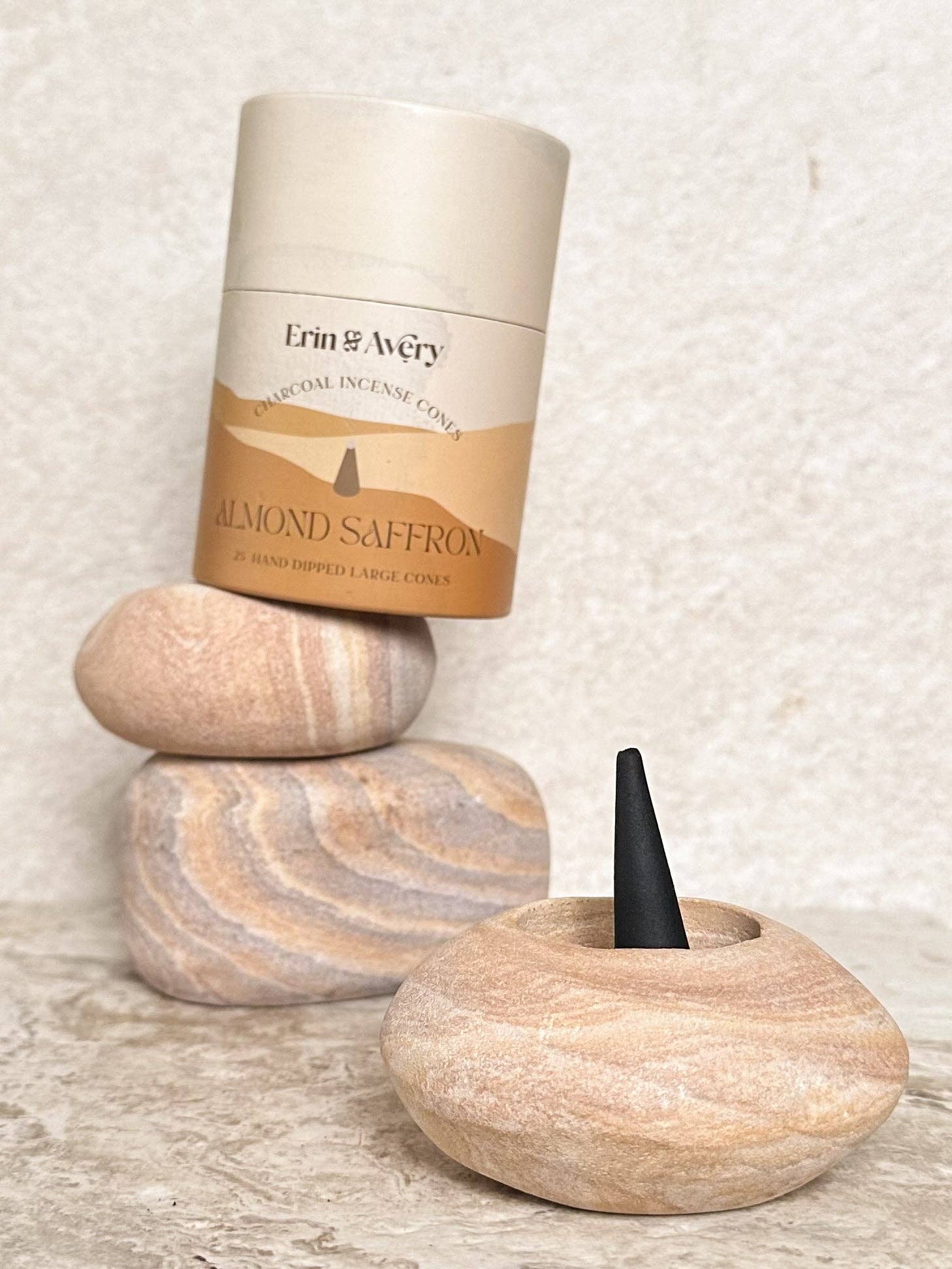 Erin & Avery almond saffron incense cone packaging with a wooden holder on a textured surface