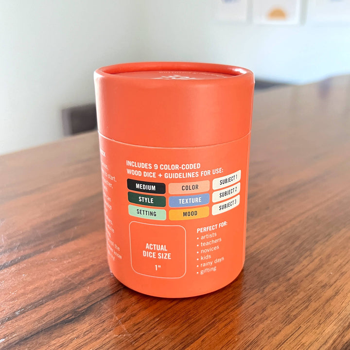 Orange dice container with text on a wooden surface