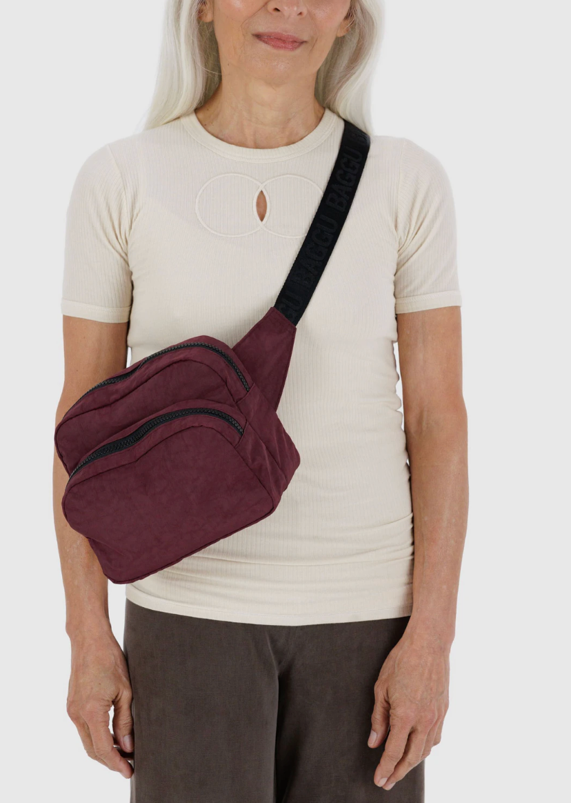 person in creame top and brown bottoms wearing baggu fanny pack in mahogany across chest