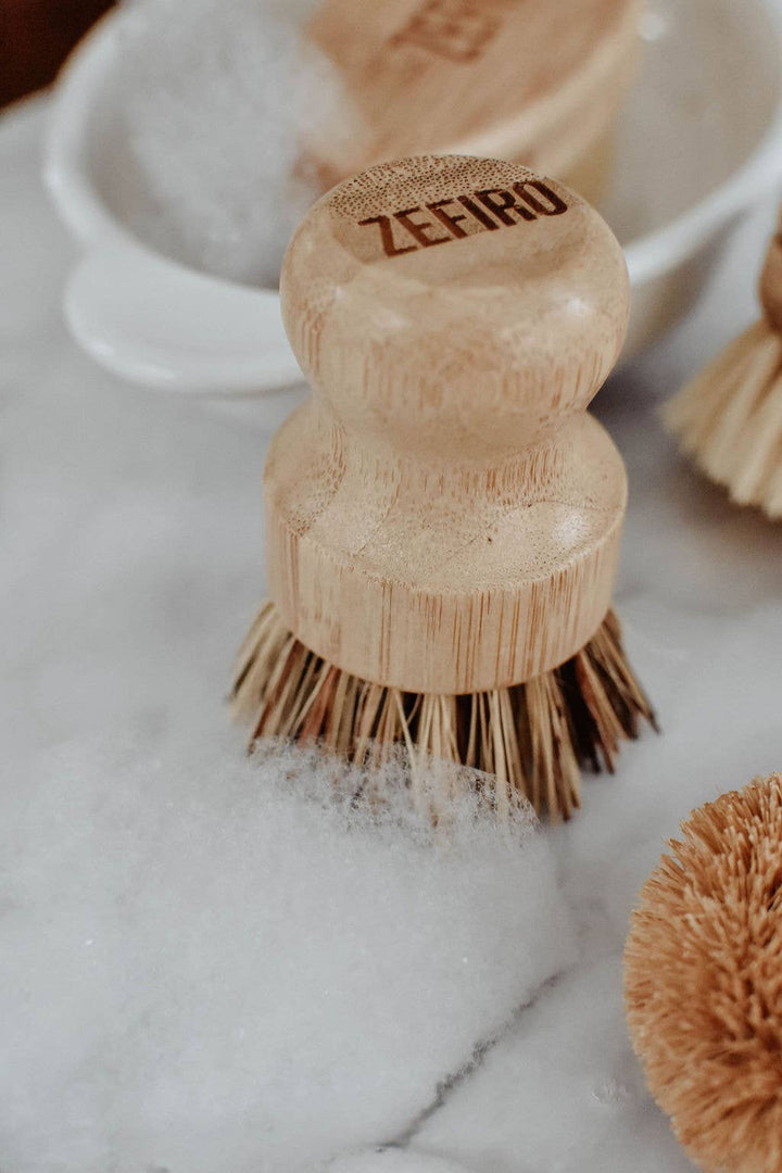 Wooden dish brush with bristles on a marble surface