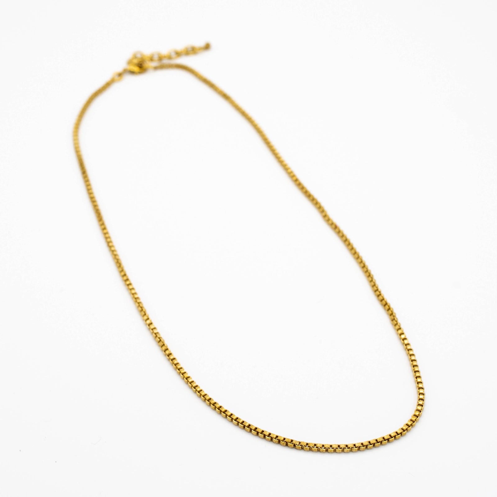 brass chain necklace on a white background