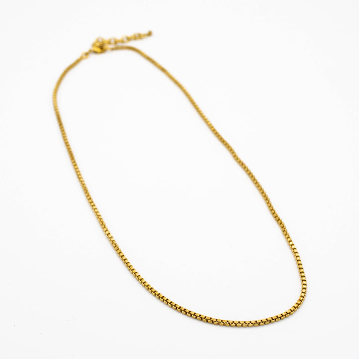 brass chain necklace on a white background
