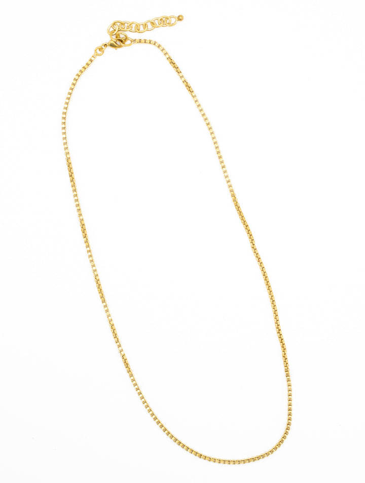 brass necklace on a white background
