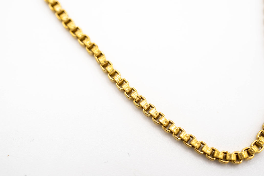 close up of brass chain on a white background