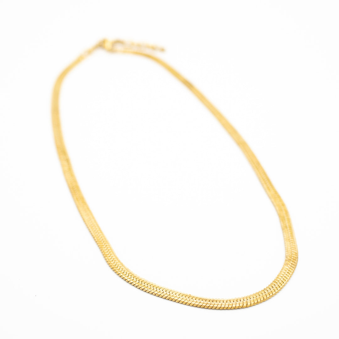 brass necklace on a white background