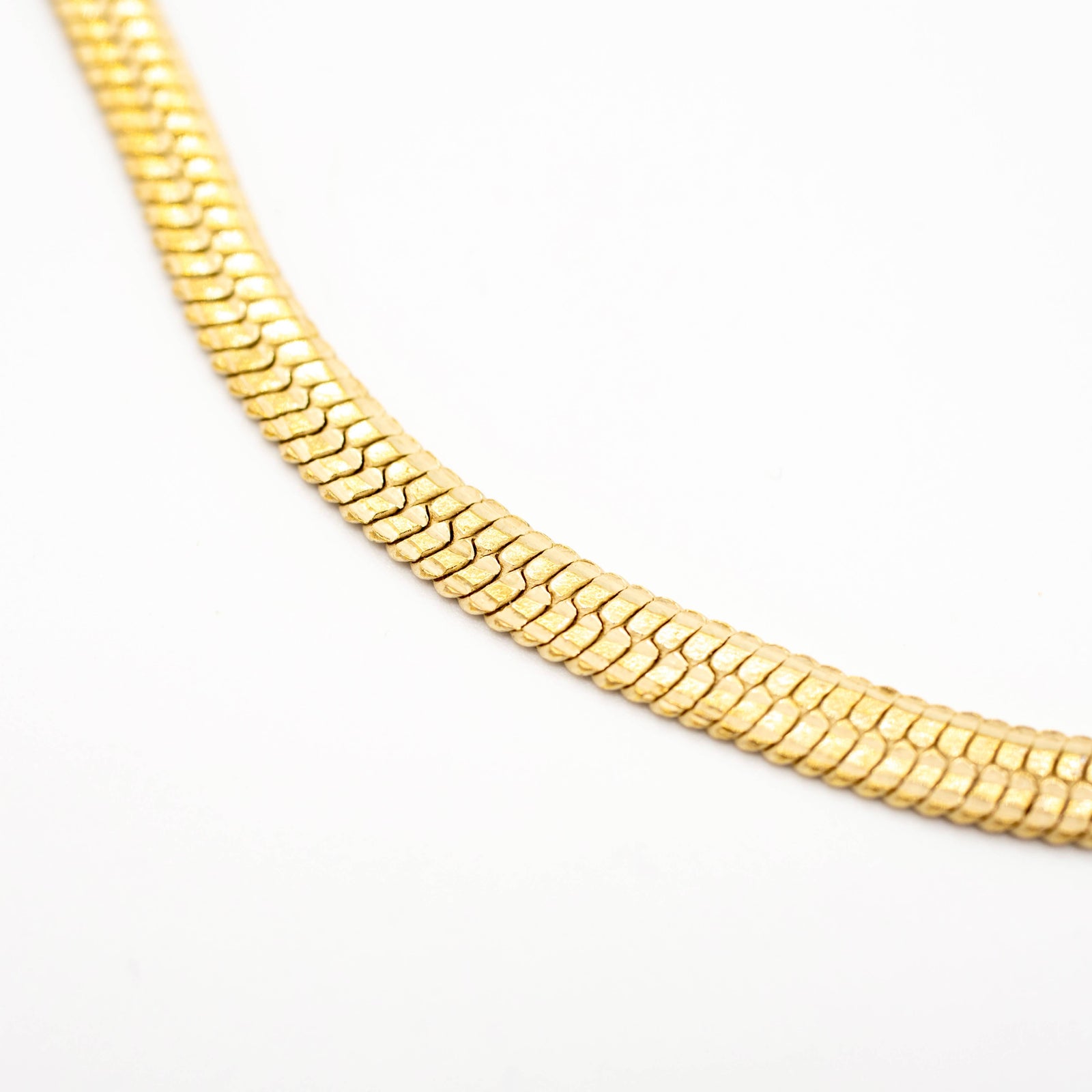 closeup of brass chain necklace on a white background