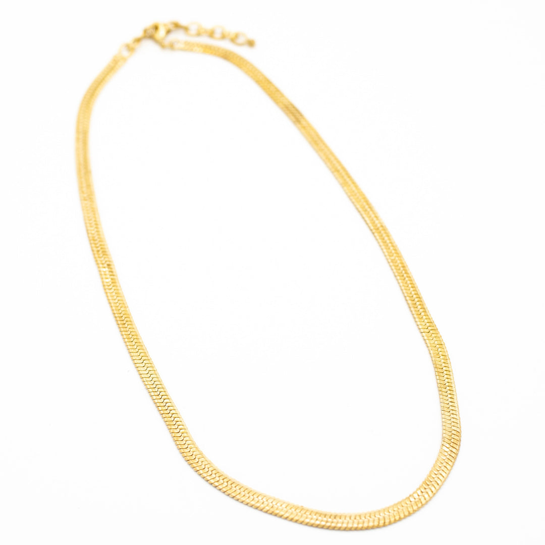 brass necklace on a white background