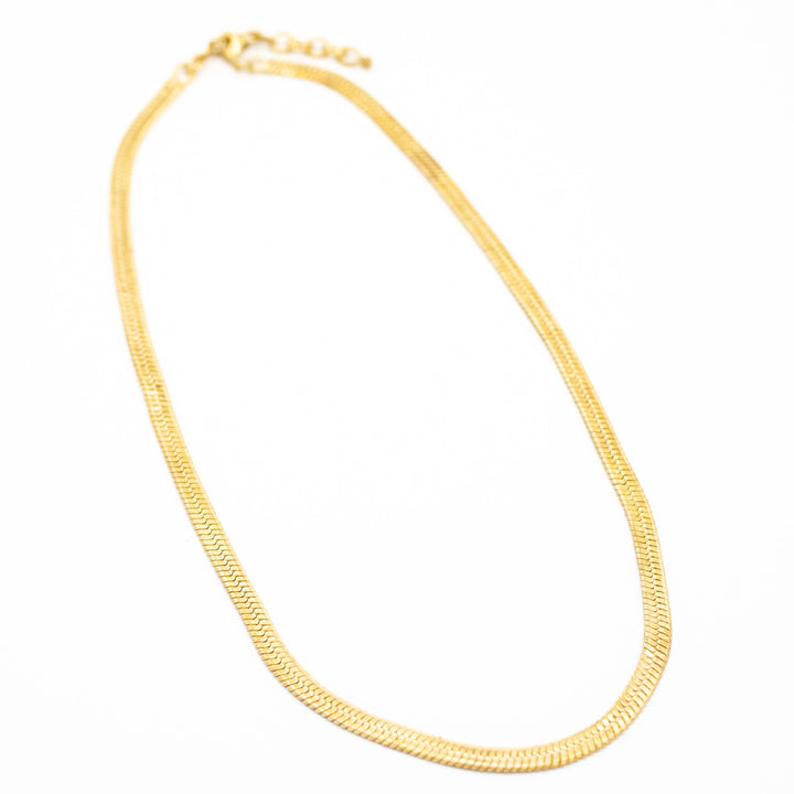 brass necklace on a white background