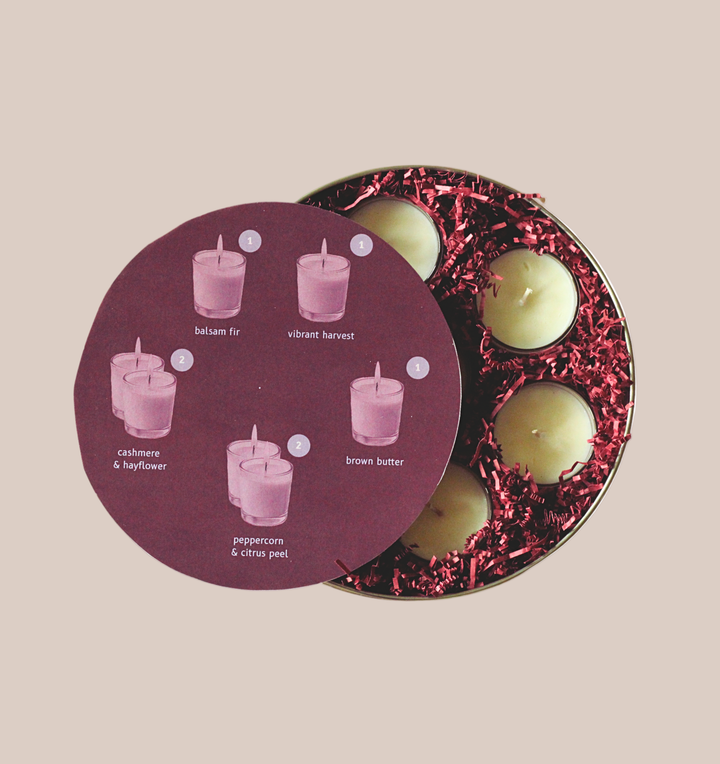 Set of candles in a tin with a purple label on a beige background