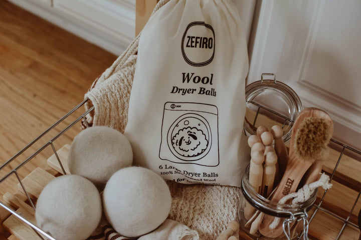 Wool dryer balls with a Zefiro branded bag in a laundry basket.