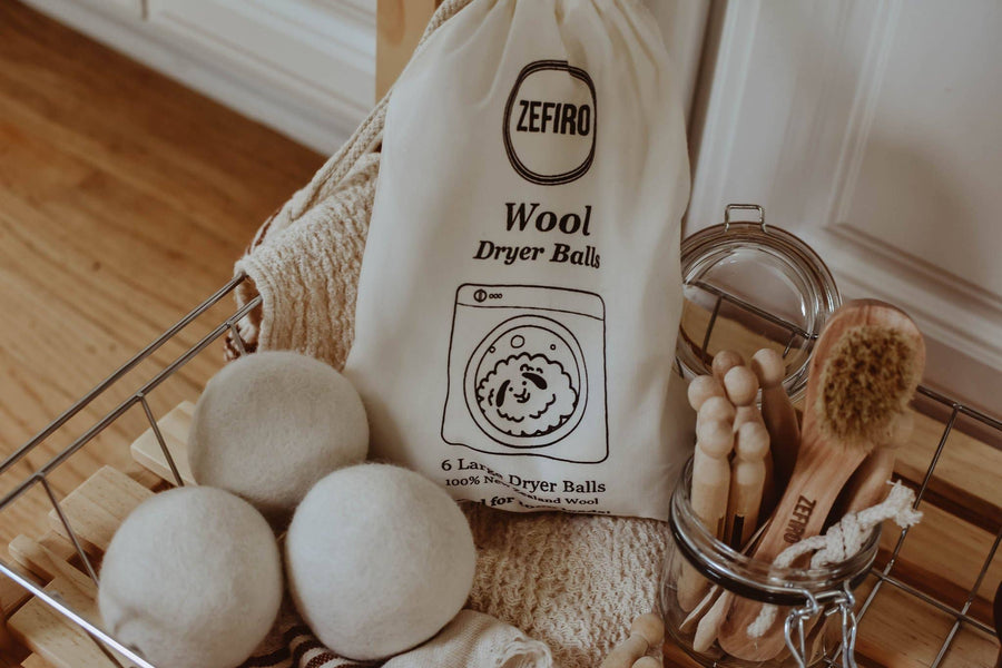 Wool dryer balls with a Zefiro branded bag in a laundry basket.