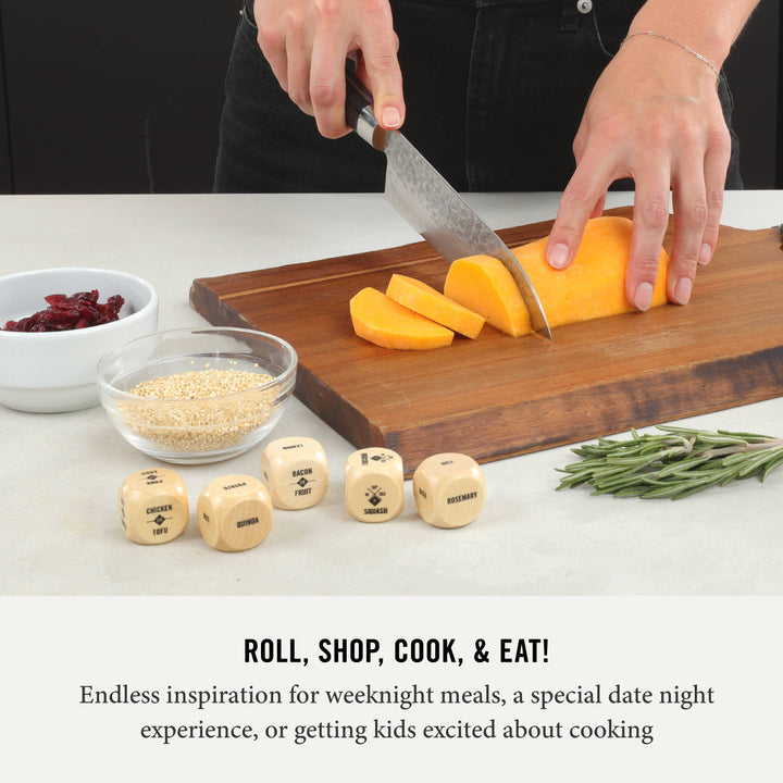 Person cutting squash on a wooden cutting board with dice and ingredients on a table.