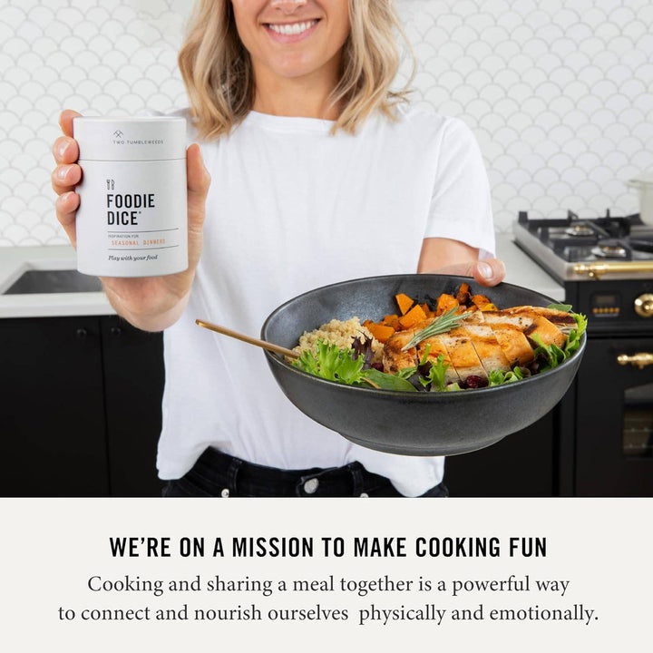 Person holding a bowl of food and a container labeled 'Foodie Dice' in a kitchen setting.
