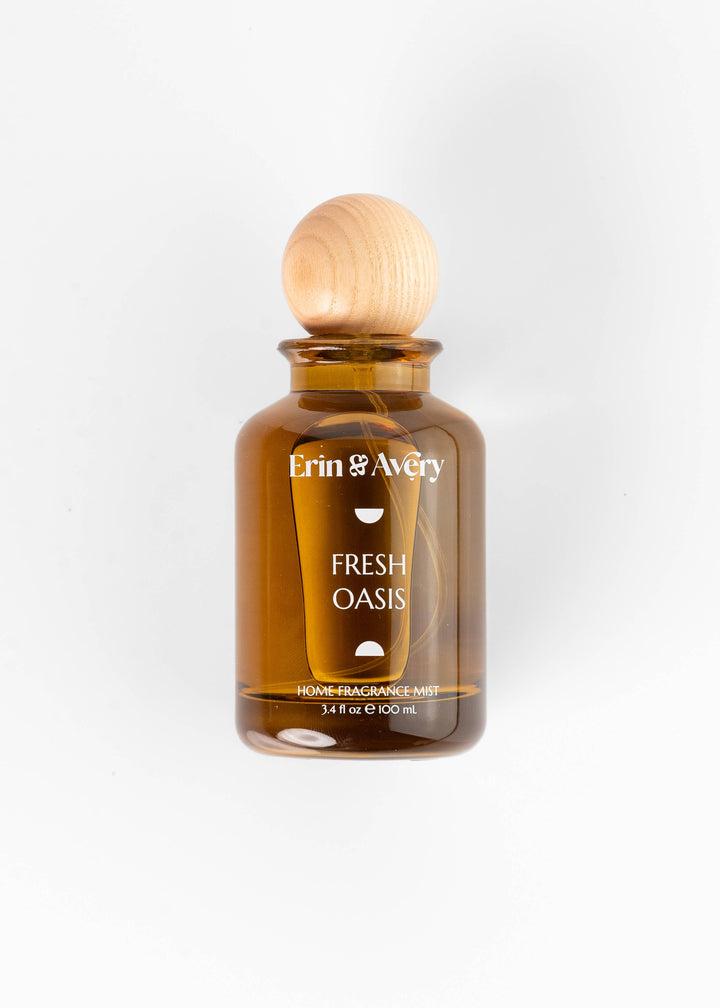 Erin &amp; Avery Fresh Oasis Home Fragrance Mist in an amber glass bottle with a light wood ball cap, shown on a clean white background.