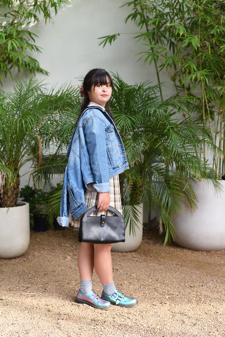 Woman in a denim jacket standing among potted plants