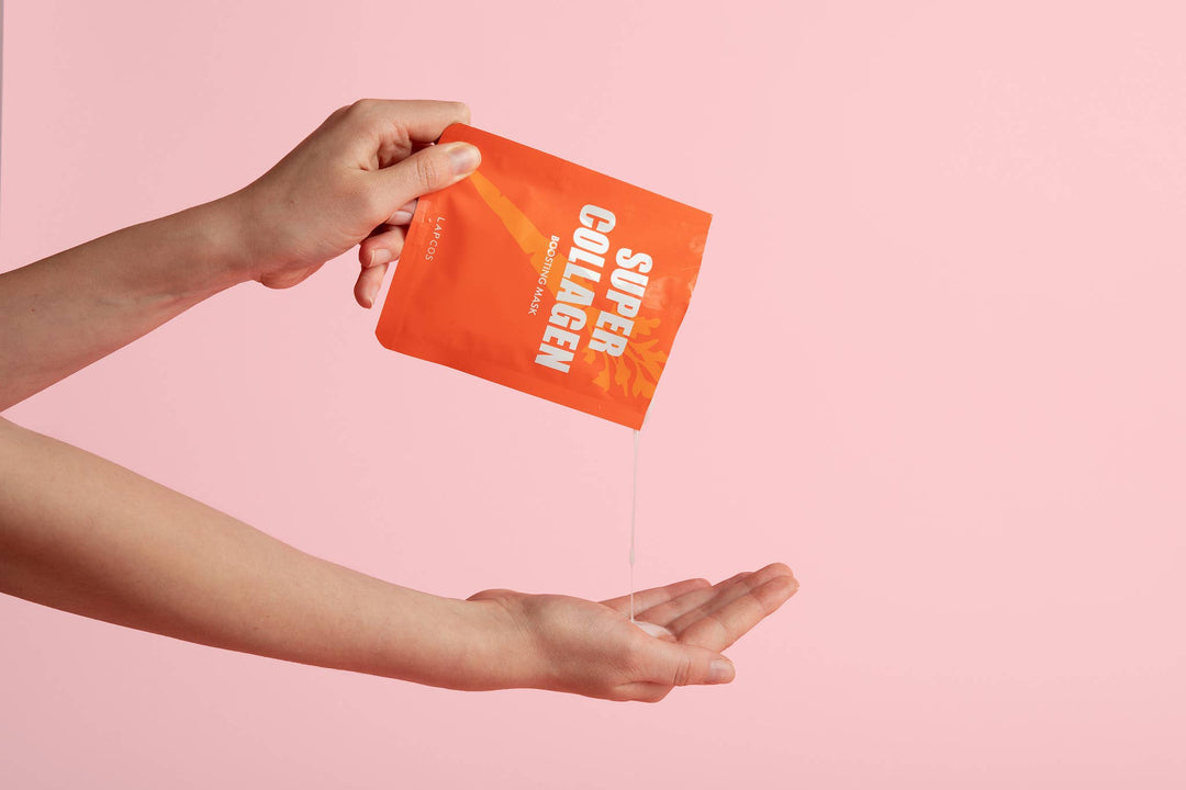 Hand holding a 'Super Collagen' packet against a pink background