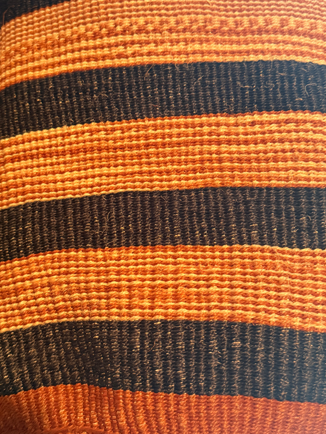Close-up of striped african tote with orange and blue horizontal bands