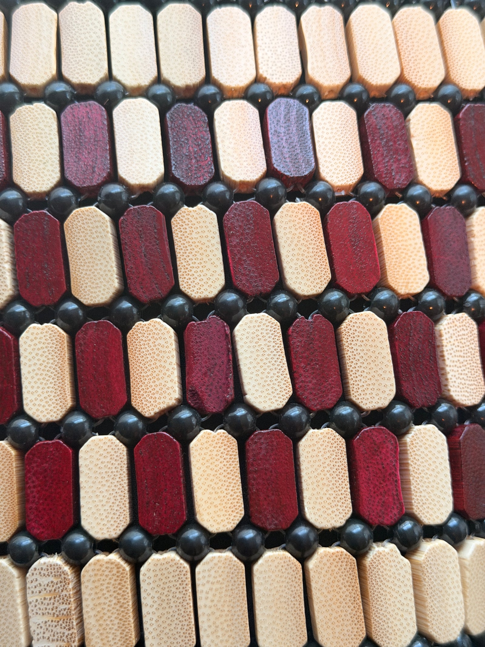 Close-up of a patterned material with maroon, beige, and black colors.