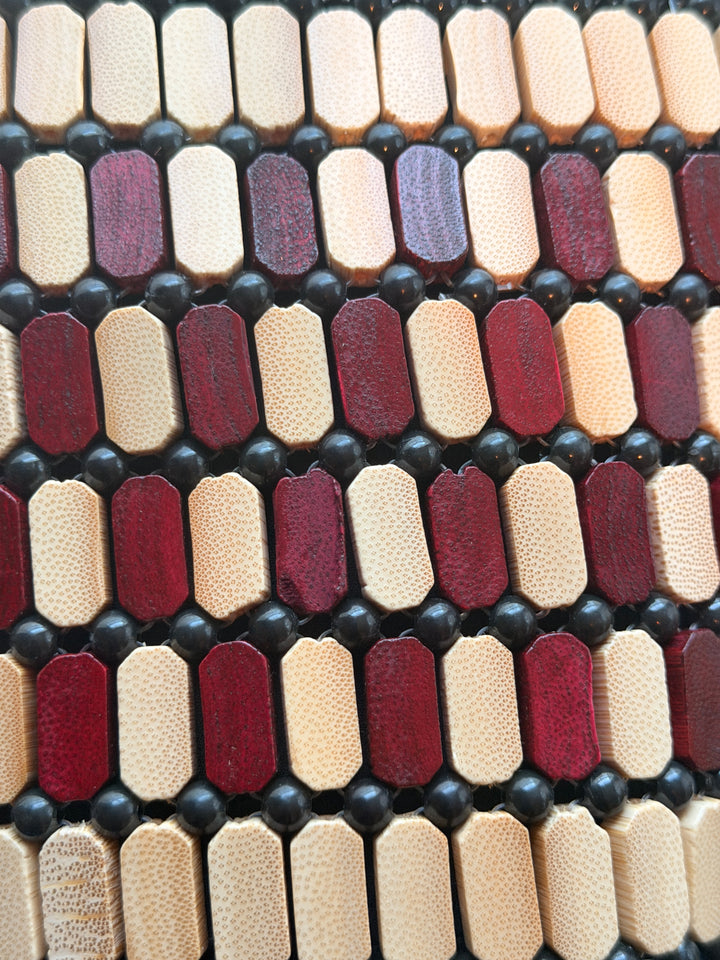 Close-up of a patterned material with maroon, beige, and black colors.