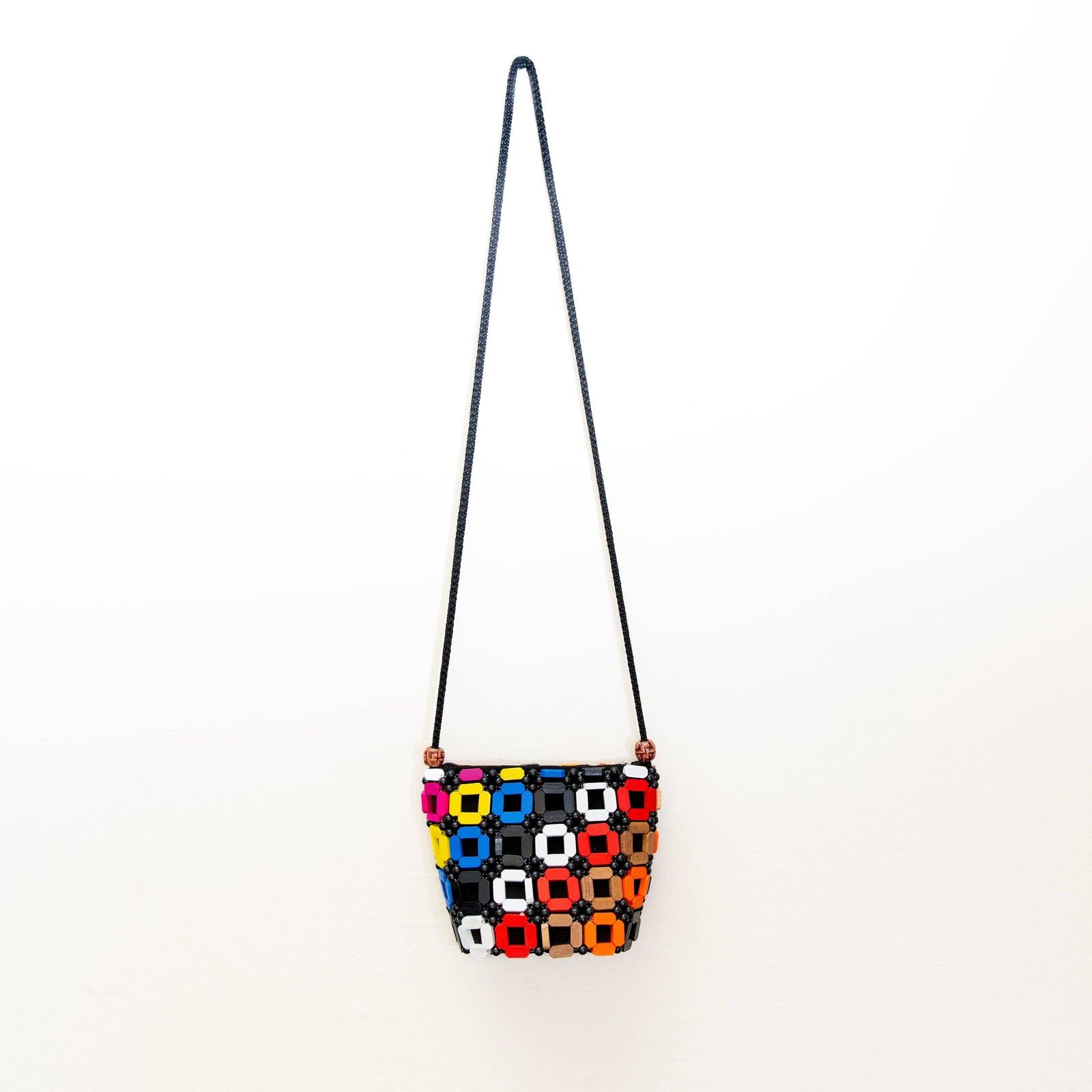 Colorful geometric-patterned bag with a strap on a white background