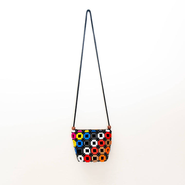 Colorful geometric-patterned bag with a strap on a white background