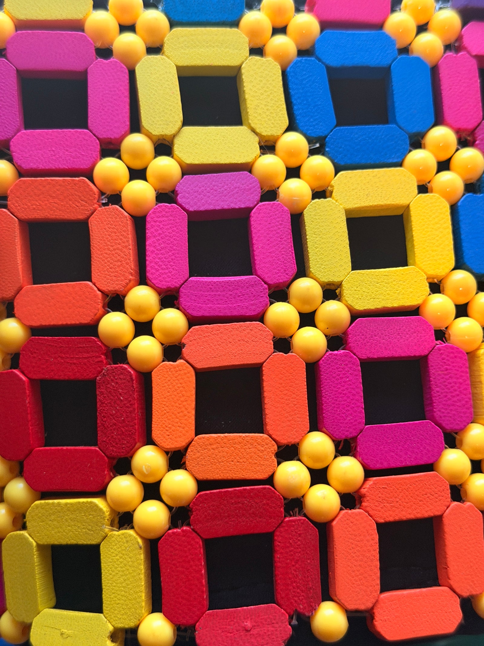Colorful foam blocks with geometric shapes and small balls on a textured surface