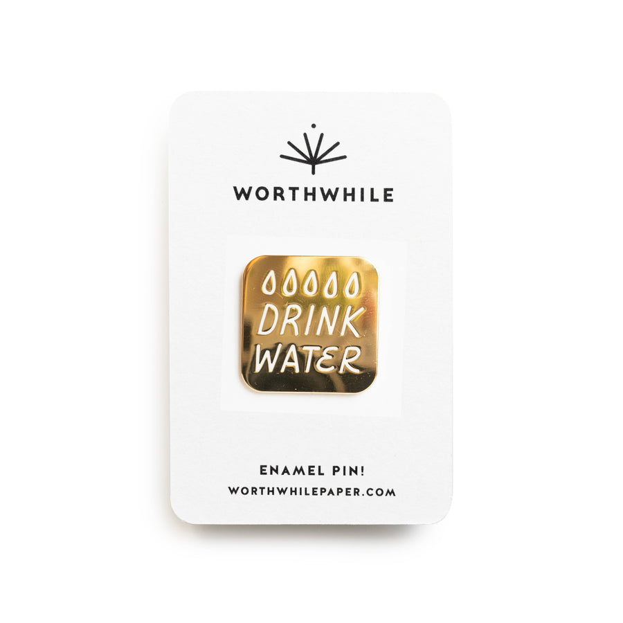 Enamel pin with 'Drink Water' text on a white card with 'Worthwhile' branding.