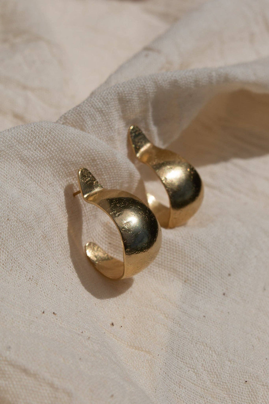 The ‘Sina’ Earrings (meaning ‘To Pinch’ in Tumbuka) are the epitome of organic elegance. Hand-forged from brass and sterling silver posts coated in a luxuriously thick layer of 14k recycled gold, these sophisticated yet natural earrings have all the style of a luxury piece while remaining lightweight, comfortable, and low key enough for everyday wear.