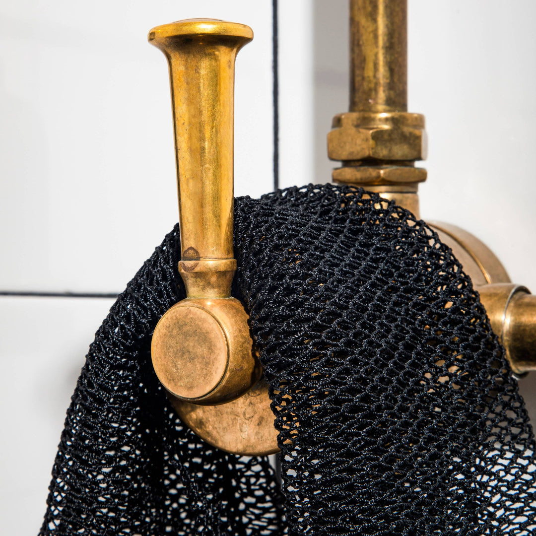 Close-up of a black chainmail shirt with gold accents on a white background