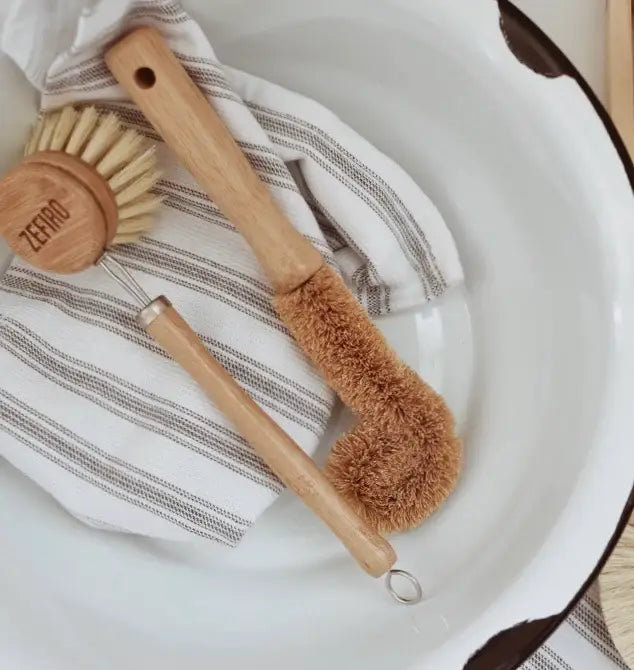 Set of wooden cleaning brushes on a towel with a white background