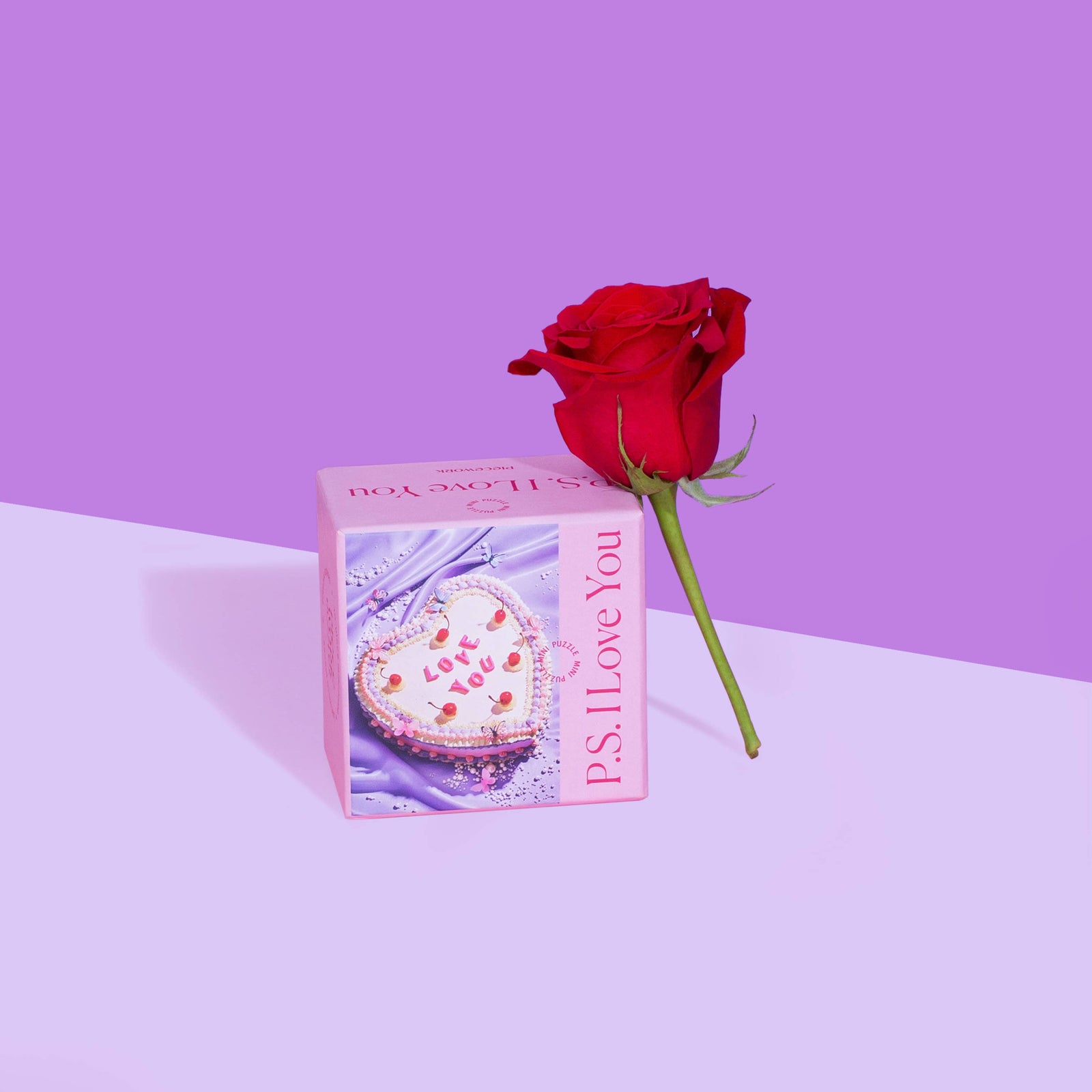 P.S. I Love you Mini Puzzle Box with a red rose leaning against it on a dark and light purple background