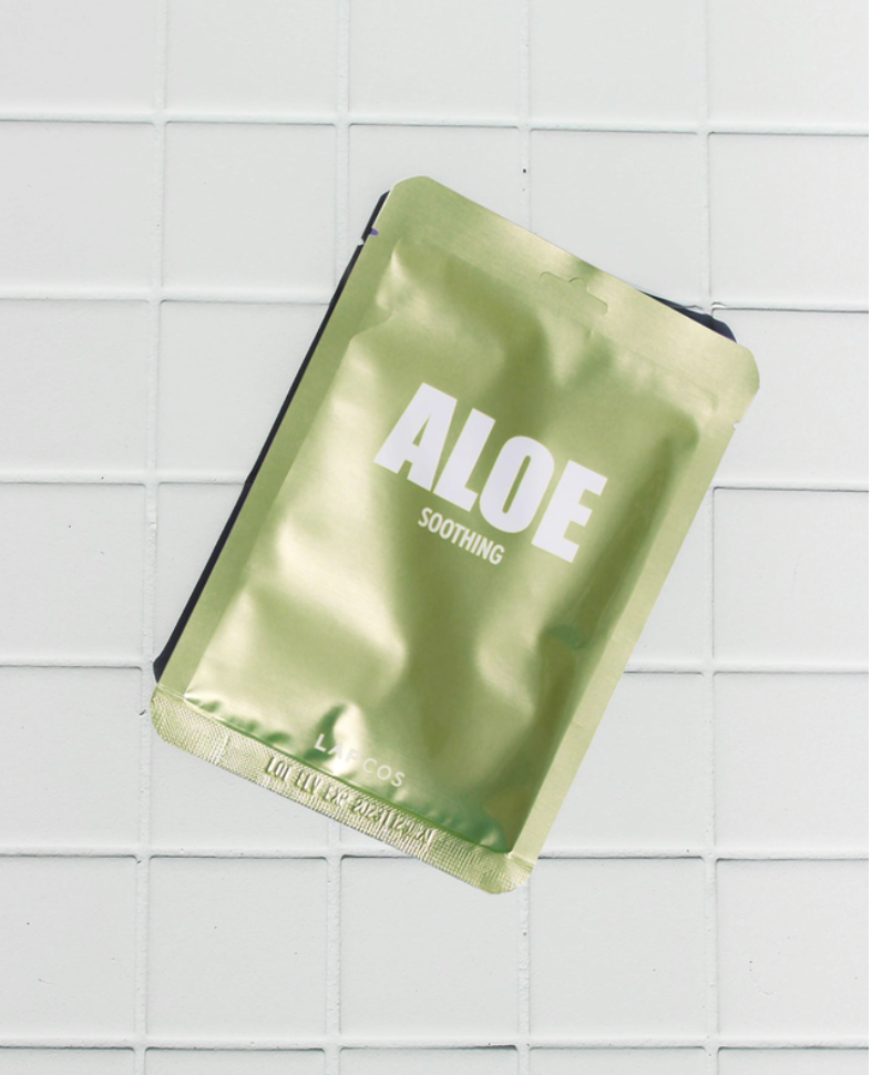 aloe sheet mask soothing on white tile backdrop